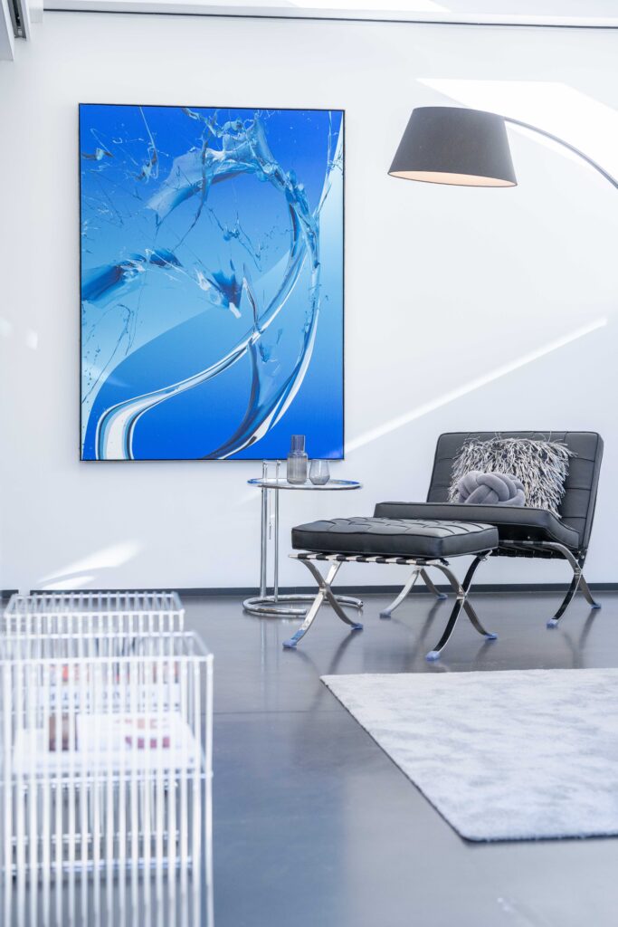 Elegantes Wohnzimmer mit modernem Kunstwerk, stilvollem Sessel und minimalistischer Einrichtung in einer Luxusimmobilie in Heidelberg Neuenheim.