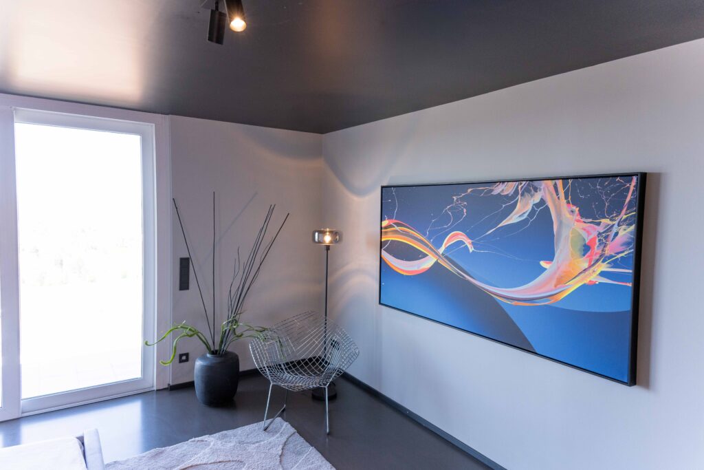 Wohnraum mit großformatiger Kunst, klaren Linien und großzügigen Fenstern.