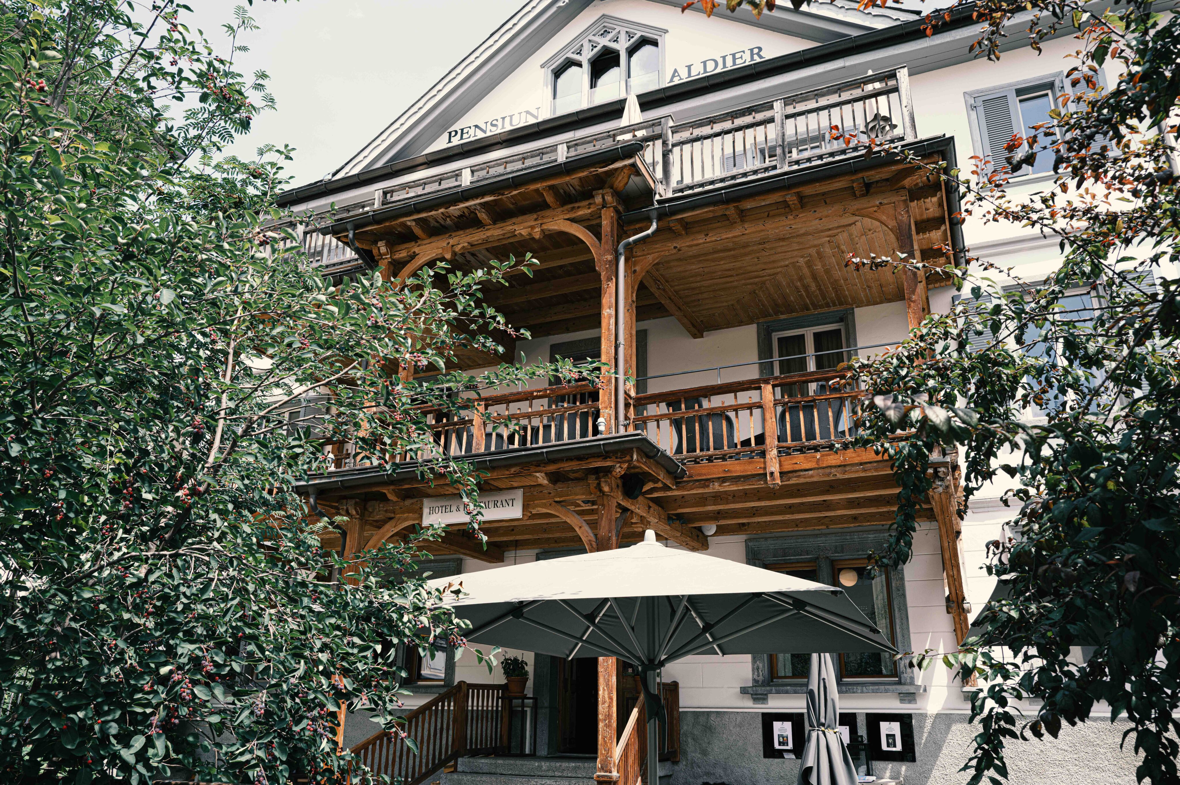 Historische Fassade mit Holzbalkon, fein gegliederten Fenstern und handwerklichen Details.