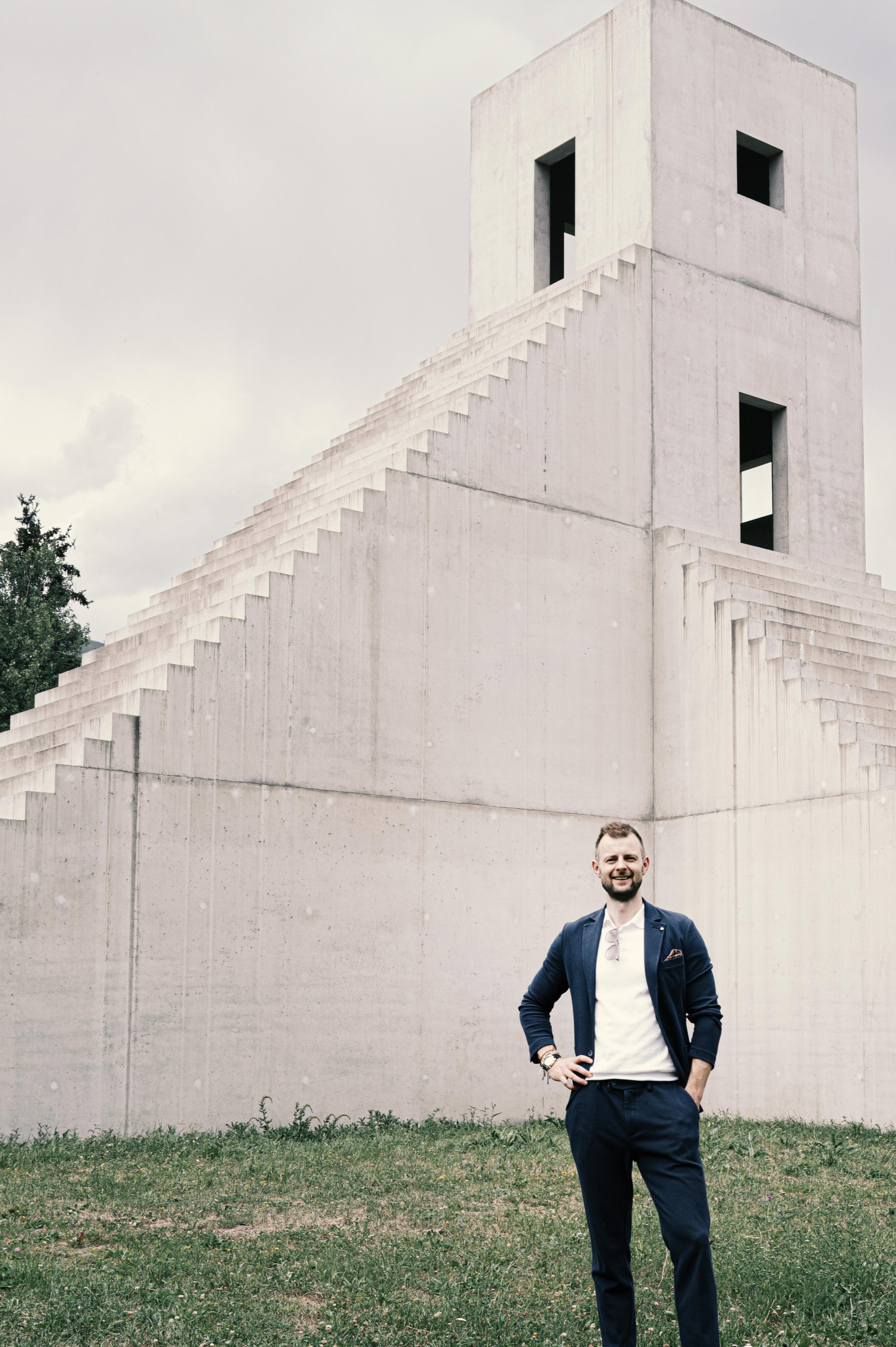 Marian D. Wensky vor moderner, skulpturaler Betonarchitektur.